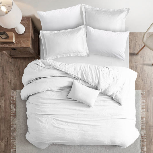 Overhead view of a neatly made bed with a white sheet, pillows, and a quilt, showcasing a serene bedroom setting