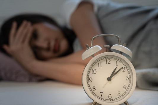 Asian woman in bed late trying to sleep.